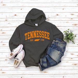 May include: A charcoal gray hooded sweatshirt with the text "Tennessee" in orange, featuring an outline of the state of Tennessee and the text "Est. 1796".