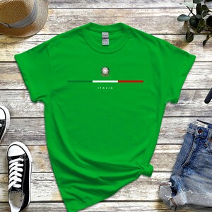 Puede incluir: Una camiseta verde con una franja blanca y la bandera italiana con el texto "ITALIA" debajo.