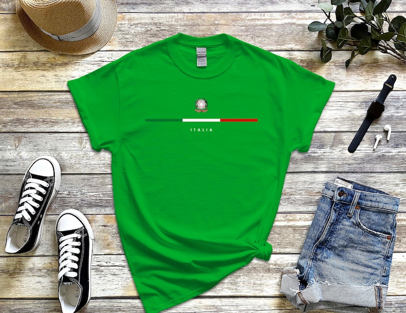 Puede incluir: Una camiseta verde con una franja blanca y la bandera italiana con el texto "ITALIA" debajo.