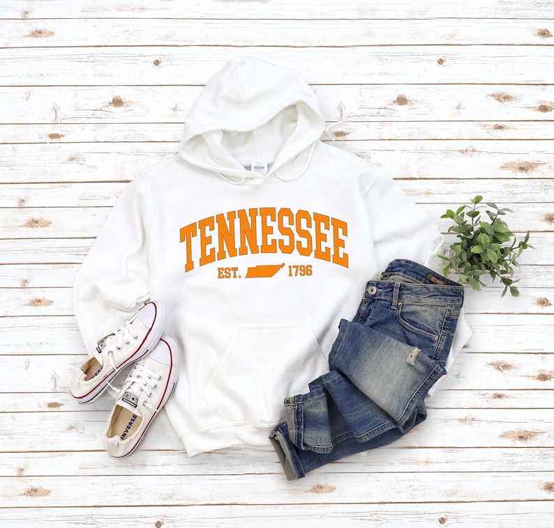 May include: White hooded sweatshirt with the text "Tennessee Est. 1796" in orange with an outline of the state of Tennessee in orange.