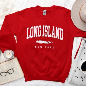 K&ouml;nnte beinhalten: Roter Pullover mit wei&szlig;em Text "Long Island, New York" und einer wei&szlig;en Umrandung von Long Island.