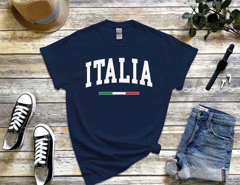 May include: A navy blue t-shirt with the word "ITALIA" in white text and the Italian flag colors in a thin stripe below the word.