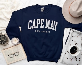 May include: A navy blue sweatshirt with white text that reads "CAPE MAY NEW JERSEY".