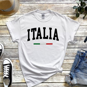 May include: White t-shirt with black text that says "ITALIA" and a green, white, and red stripe underneath.