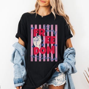 May include: Black t-shirt with a graphic that reads "250 years of FREEDOM" in red letters, with a raised fist and stars. The text "terms & conditions apply" is below the main text.