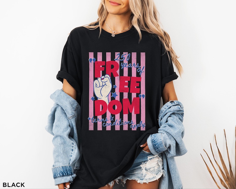 May include: Black t-shirt with a graphic that reads "250 years of FREEDOM" in red letters, with a raised fist and stars. The text "terms & conditions apply" is below the main text.