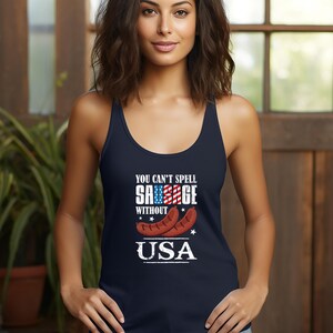 Puede incluir: Una camiseta sin mangas azul marino con el texto "You can't spell sausage without USA" y un gráfico de dos salchichas con un diseño de bandera estadounidense.