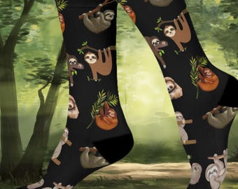 May include: A pair of black socks with a repeating pattern of sloths hanging from branches. The sloths are brown and tan with black eyes and noses.