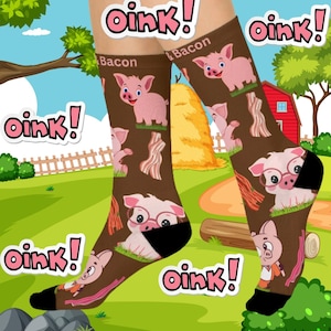 May include: A pair of brown socks with a pink pig and bacon print. The socks have the text "Oink! & Bacon" on them.