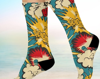 May include: A pair of colorful socks with a comic book style design. The socks feature yellow, red, blue, and white explosions with the words "BOOM" and "BAD" printed on them.