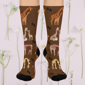 May include: A pair of brown socks with a pattern of giraffes and their footprints. The giraffes are in various poses, including standing, walking, and kissing.