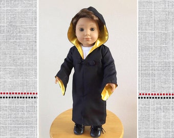 May include: A black doll robe with gold trim and a hood. The robe has a button closure and is called "Malcolm's Character Robe".