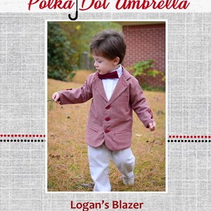 Puede incluir: Un niño pequeño con un blazer a cuadros rojo y blanco con una corbata de lazo burdeos. El blazer tiene cierre de botones y bolsillos. El niño está de pie en un área cubierta de hierba con una pared de ladrillo en el fondo. El texto "Logan's Blazer" está en la parte inferior de la imagen.