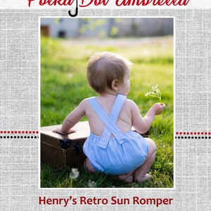 May include: A baby wearing a blue and white striped romper with a white button and an X-shaped strap in the back. The romper is called "Henry's Retro Sun Romper".