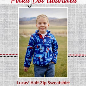 May include: A blue half-zip sweatshirt with a tool pattern. The sweatshirt is being worn by a young boy standing in a grassy field. The text "Lucas' Half-Zip Sweatshirt" is at the bottom of the image.