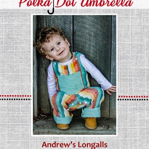 Puede incluir: Un niño pequeño con un mono de rayas azul verdoso y arcoíris con una camisa blanca de manga larga. El niño está sentado en un escalón de madera con una puerta de madera detrás de él. La imagen tiene el título "Andrew's Longalls".