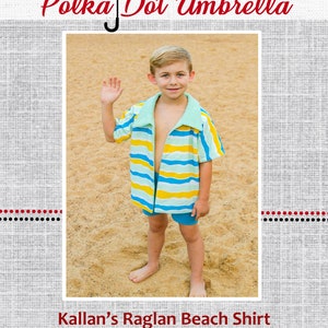 Könnte beinhalten: Ein kleiner Junge trägt ein blau-gelb gestreiftes Hemd mit blauem Kragen und einen blau-weißen Polka-Dot-Schirm vor einem grauen Hintergrund. Der Text "Polka Dot Umbrella" befindet sich über dem Bild und der Text "Kallan's Raglan Beach Shirt" unter dem Bild.