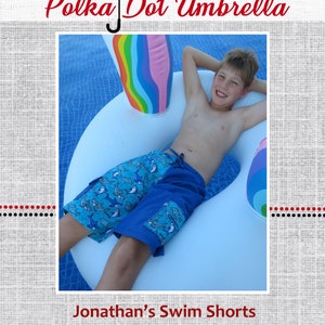 Può includere: Un ragazzo indossa pantaloncini da bagno blu con stampa di squali e galleggia in una piscina su un anello gonfiabile bianco con una striscia arcobaleno. Il testo "Jonathan's Swim Shorts" è in basso nell'immagine.