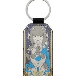 May include: A gray and white keychain featuring a cartoon illustration of Midna from The Legend of Zelda: Twilight Princess. The keychain is shaped like a card with a gold border and the word "Midna" printed at the bottom.
