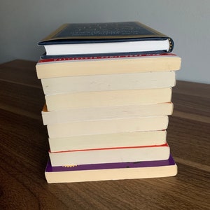 Pu&ograve; includere: Una pila di dieci libri, per lo pi&ugrave; color crema con alcune copertine colorate. Il libro in cima &egrave; blu scuro con lettere dorate che recitano "The Gifts of Imperfection: Let Go of Who You Think You're Supposed to Be and Embrace Who You Are".