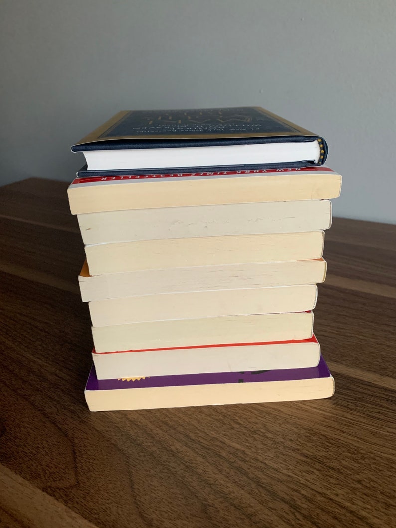 Pu&ograve; includere: Una pila di dieci libri, per lo pi&ugrave; color crema con alcune copertine colorate. Il libro in cima &egrave; blu scuro con lettere dorate che recitano "The Gifts of Imperfection: Let Go of Who You Think You're Supposed to Be and Embrace Who You Are".