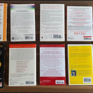 Pu&ograve; includere: Copertine posteriori di dieci diversi libri tascabili su una superficie di legno. I libri sono di colori diversi e hanno titoli diversi. Alcuni dei titoli includono "Leggi te stesso in una fortuna", "Pap&agrave; ricco, pap&agrave; povero", "Successo" e "Tu sei un marchio".