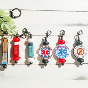 May include: Five colorful keychains with different medical alert messages. The keychains are made of black, red, and white beads with a metal clip. The messages include "I Carry An EpiPen", "I Carry An Inhaler", "Type 1 Diabetic Insulin In Bag", "Medical Alert Type 2 Diabetic", and "No Peanuts Allergy Alert".