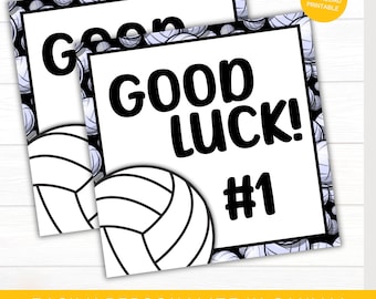 May include: Two white gift tags with a volleyball design and the words "GOOD LUCK! #1" in bold black letters. The tags have a black border and a volleyball pattern. The text "EASILY PERSONALIZE IN CANVA! EDITABLE VOLLEYBALL GIFT TAGS" is at the bottom.