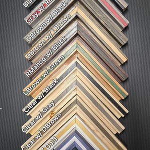 May include: A display of pinstripe floating frame samples in various colors and finishes. The frames are labeled with color combinations like "Black w/ Gold" and "Green w/ LBrown". The image includes both gloss and matte finishes.
