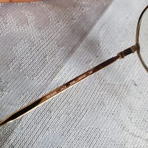 Pu&ograve; includere: Una tazza di ceramica bianca con manico nero e la scritta "But First, Coffee" in grassetto nero. La tazza &egrave; posta su uno sfondo neutro, evidenziando il suo design semplice.