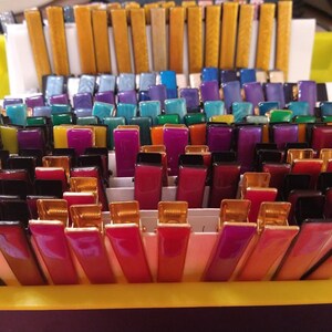 Peut inclure: Une collection de pinces &agrave; cheveux color&eacute;es dans une vari&eacute;t&eacute; de couleurs, notamment l'or, le bleu, le vert, le violet, le rouge et le noir. Les pinces sont dispos&eacute;es en rang&eacute;es et sont toutes de la m&ecirc;me taille et de la m&ecirc;me forme.