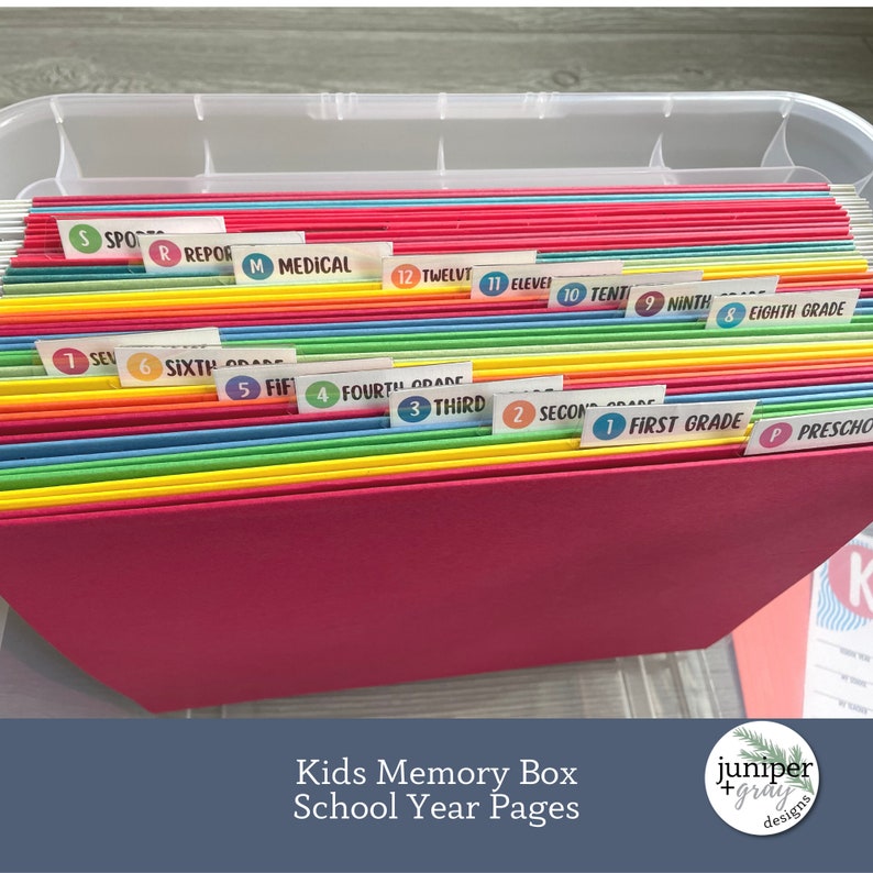 May include: A clear plastic storage box filled with colorful file folders labeled with numbers and grade levels, such as "First Grade", "Second Grade", "Third Grade", and "Preschool". The folders are organized by grade level, with the youngest grades at the bottom and the oldest grades at the top. The box is labeled "Kids Memory Box School Year Pages".
