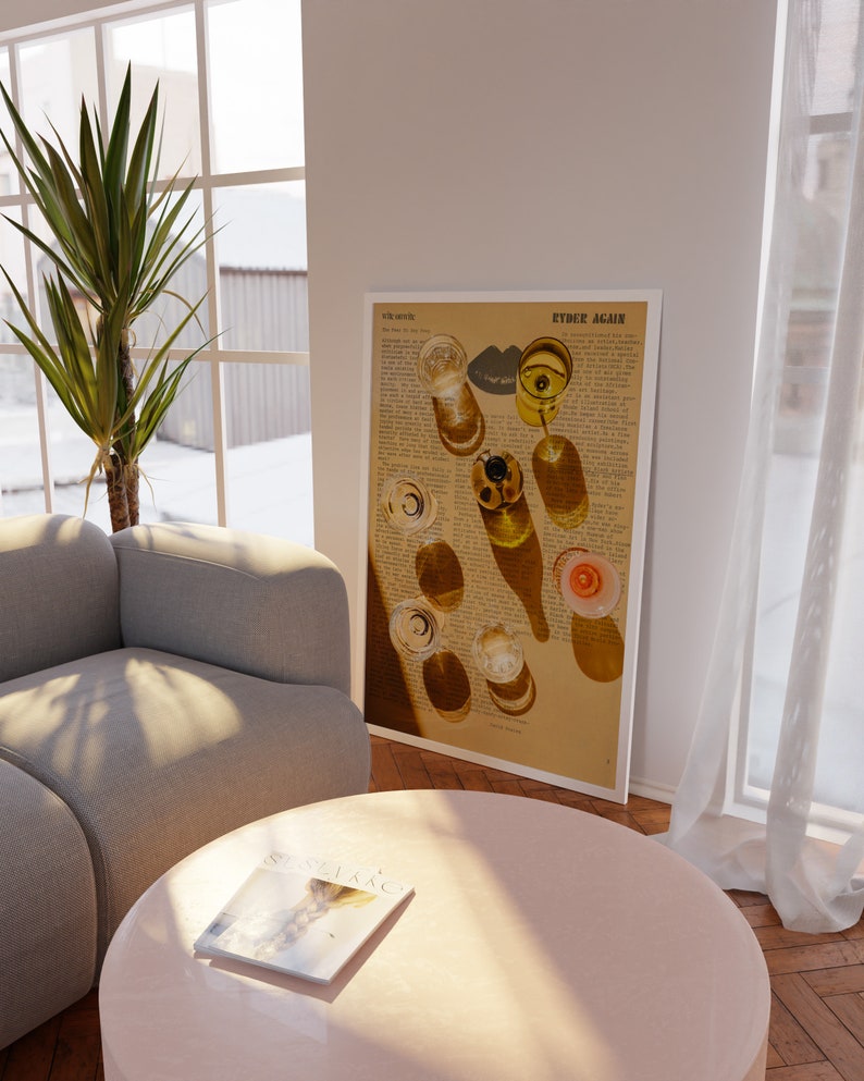 May include: A vintage-style print of glasses of wine on a newspaper background. The print has the text "Ryder Again" at the top. The print is framed and hanging on a white wall.