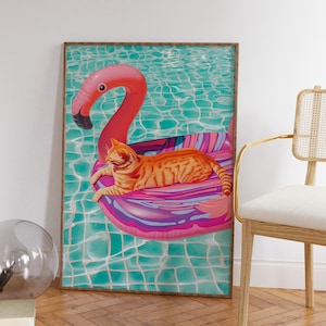 May include: A framed print of a cat lounging on a pink flamingo pool float in a turquoise swimming pool.