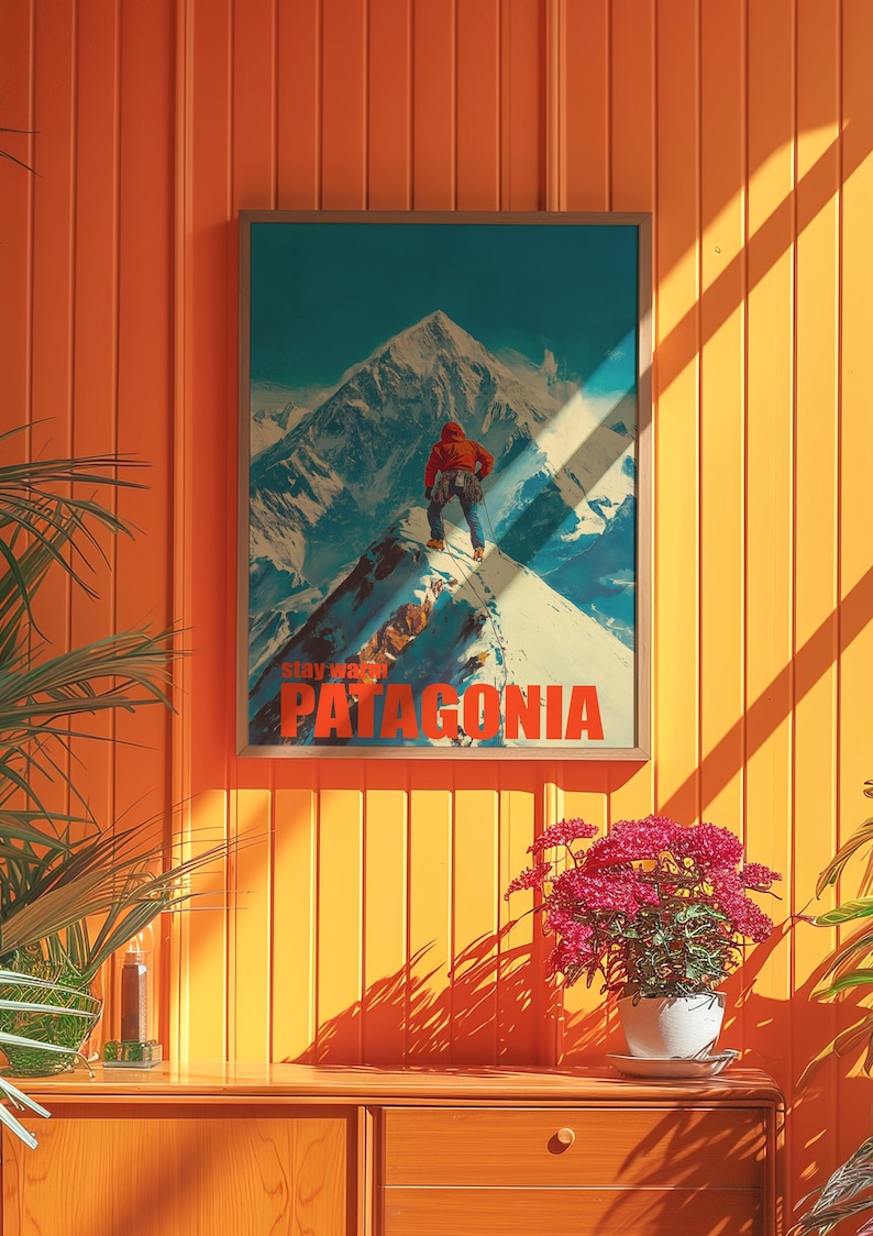 A striking poster featuring a climber in bright orange gear standing on a snowy mountain peak in Patagonia. This adventurous design captures the spirit of exploration and the beauty of the outdoors, perfect for nature lovers and thrill seekers.