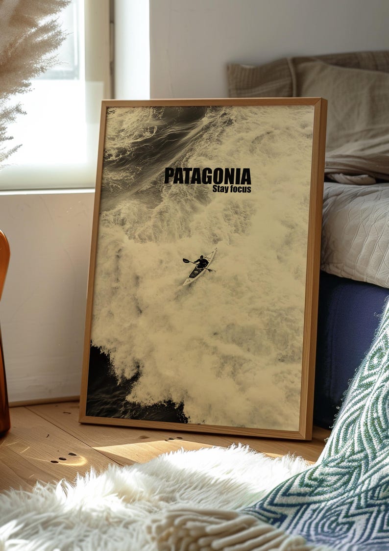 A paddler navigating rough ocean waves in a retro sepia tone. The phrase Patagonia Stay Focus highlights concentration and adventure. Perfect for water sports lovers and those seeking wilderness-inspired decor.