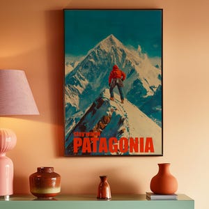 A striking poster featuring a climber in bright orange gear standing on a snowy mountain peak in Patagonia. This adventurous design captures the spirit of exploration and the beauty of the outdoors, perfect for nature lovers and thrill seekers.