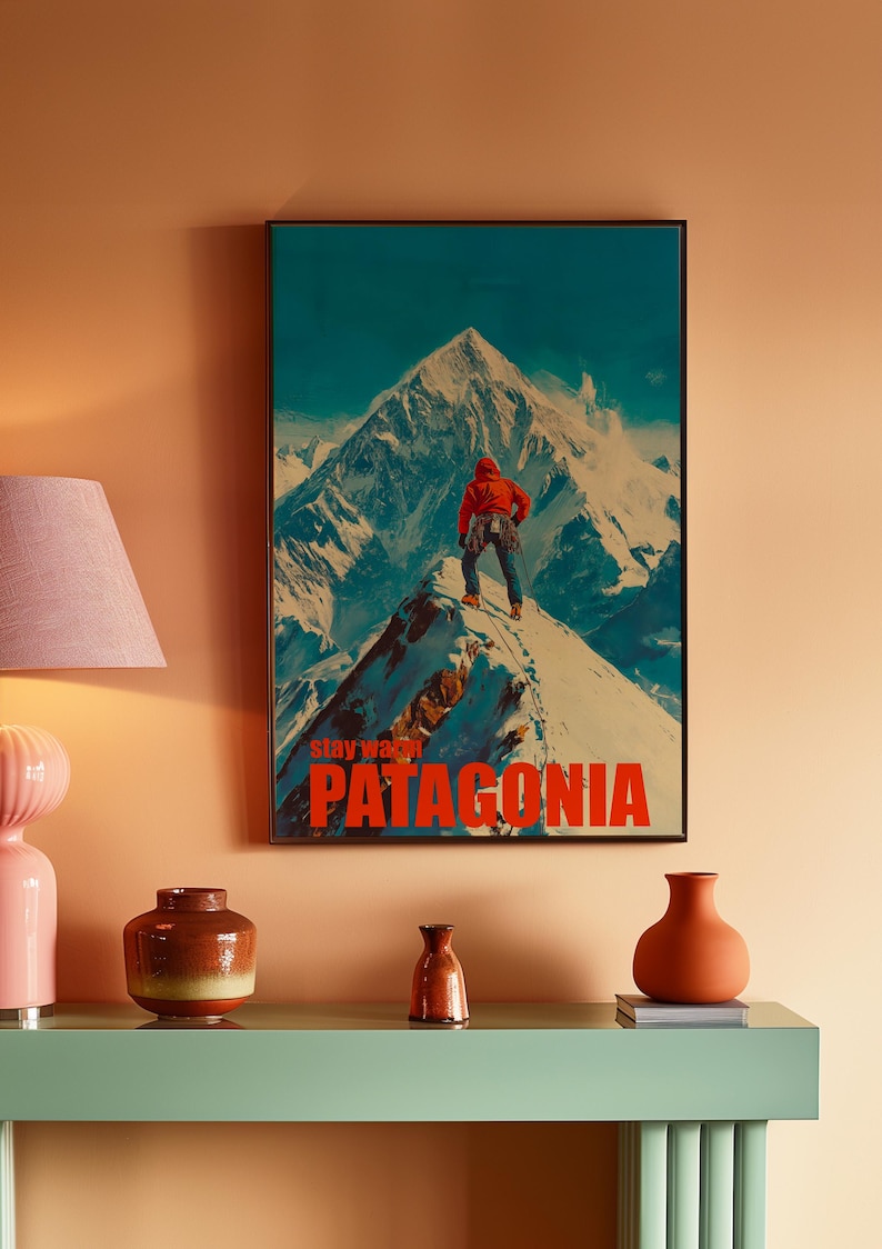 A striking poster featuring a climber in bright orange gear standing on a snowy mountain peak in Patagonia. This adventurous design captures the spirit of exploration and the beauty of the outdoors, perfect for nature lovers and thrill seekers.