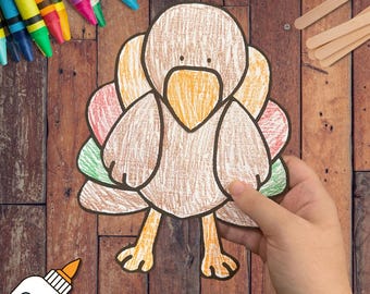 May include: A paper cutout of a turkey colored with crayons in shades of brown, orange, red, and green. The turkey features a rounded body, a prominent beak, and layered tail feathers. The craft is displayed alongside colorful crayons and sticks.