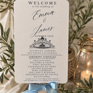 May include: A wedding fan with a light blue ribbon, featuring the names Emma & James, and the date Summer 2026. The fan includes the ceremony schedule and location: Riverside Gardens, Southern California.