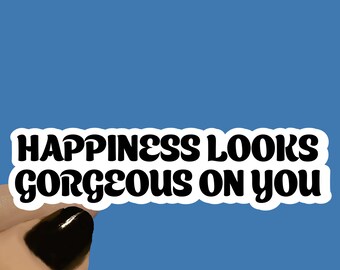 May include: White sticker with black text that reads "Happiness looks gorgeous on you". The sticker is available in 3, 4, or 5 inches in length.