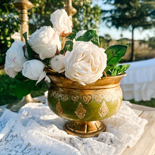 Puede incluir: Un tazón decorativo verde y dorado con rosas blancas y hojas verdes. El tazón tiene un borde dorado y diseños dorados intrincados.