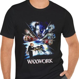 May include: Black t-shirt featuring a graphic print of a scene from the film Waxwork. The graphic depicts a group of monsters and the film title, "Waxwork", in white lettering.