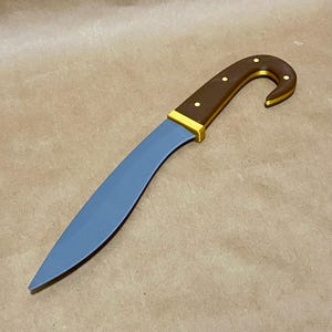 May include: A curved knife with a blue blade and a brown handle. The handle has a curved design with gold accents and small gold rivets. The blade is a light blue color, and the knife has a sharp point.