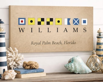 Könnte beinhalten: Ein rechteckiger Leinwanddruck mit nautischen Signalflaggen, die "WILLIAMS" über "Royal Palm Beach, Florida" buchstabieren. Der Druck hat einen beigen Hintergrund und wird auf einem Holzregal mit nautischem Dekor ausgestellt.