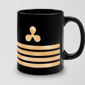 May include: Black ceramic coffee mug with a gold propeller and four gold stripes.