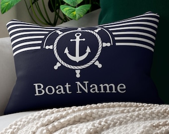 Könnte beinhalten: Marineblaues rechteckiges Kissen mit nautischem Design. Das Kissen zeigt einen weißen Anker in einem Seilkreis, ein Steuerrad und den Text "Boat Name" in Weiß. Weiße horizontale Streifen befinden sich oben.