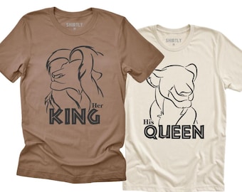 May include: Two short-sleeved t-shirts. One is brown with a lion graphic and the text "Her King". The other is off-white with a lioness graphic and the text "His Queen".