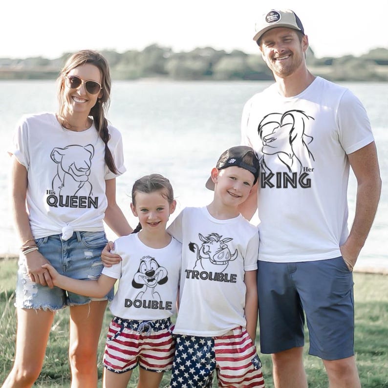 May include: A family of five wearing matching white t-shirts with black graphic designs. The shirts feature the phrases "His Queen", "Her King", "Double", and "Trouble". The children wear red and blue patterned shorts. The adults wear sunglasses and a baseball cap.