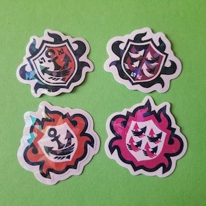 May include: Four colorful stickers with a shield design. Each sticker features a different design, including an anchor, a bird, and a stylized flame. The stickers are printed on a white background.